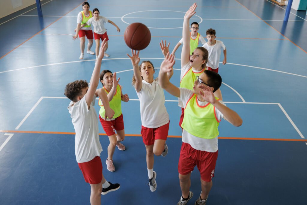 group of diverse kids playing basketball in school gym.