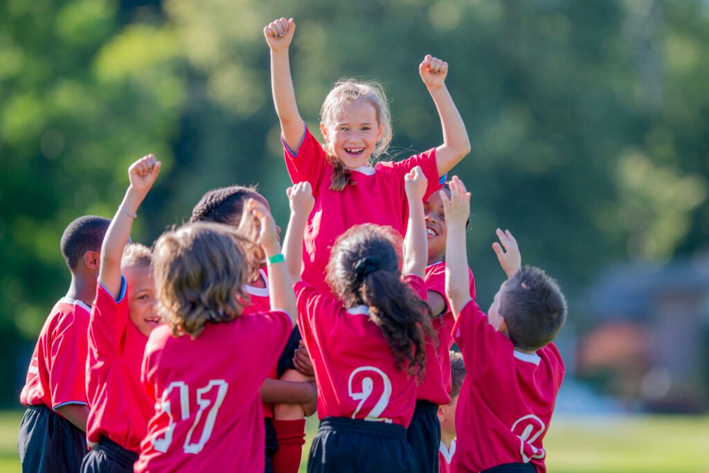 young soccer team celebrating success on the field together